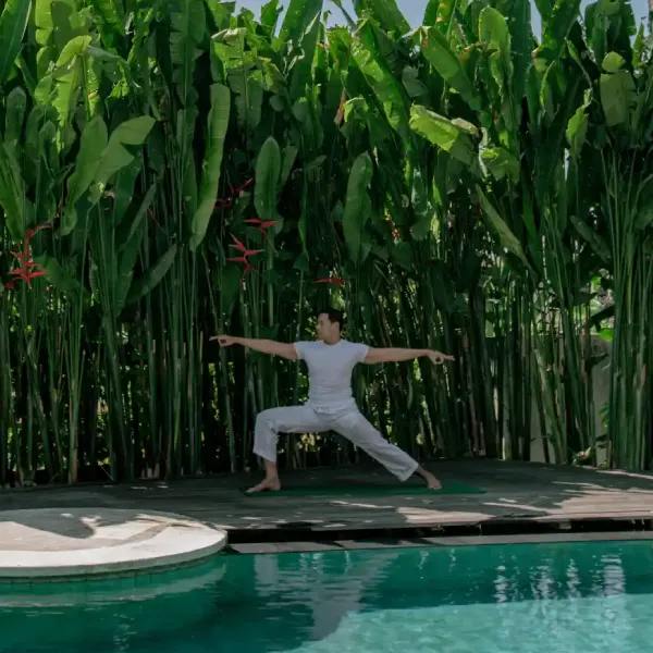 A man demonstrate a yoga move on the pool side