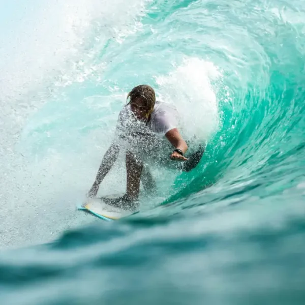 A man riding in the middle of wave using his surf board