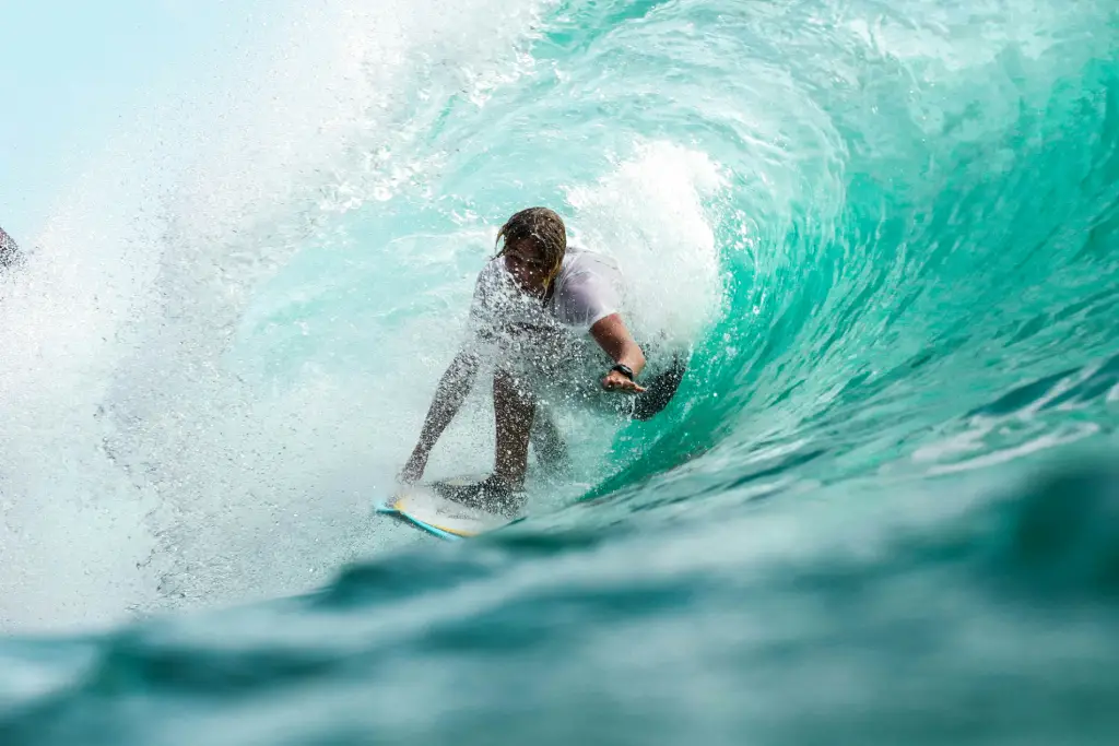 A man riding in the middle of wave using his surf board