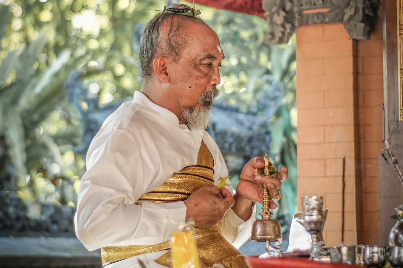 The caretaker is holding a Balinese Hindu religious ceremony