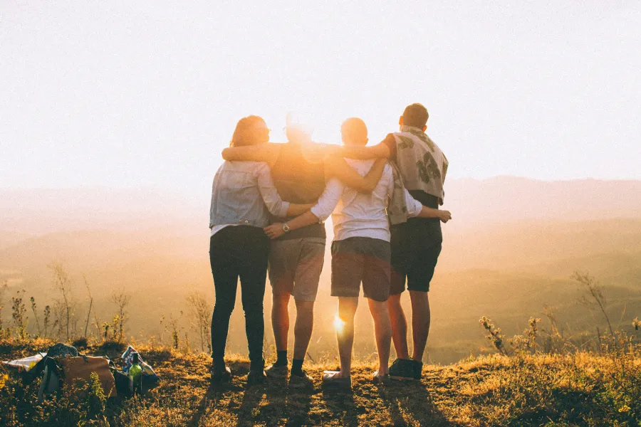 friends holding eachother while looking at the sund