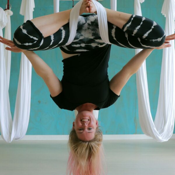 a girl doing a flip yoga move with hanging hammock